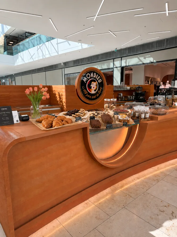 Barista obsluhuje hostí v kiosku Mondieu Specialty Coffee v Eurovei v Bratislave